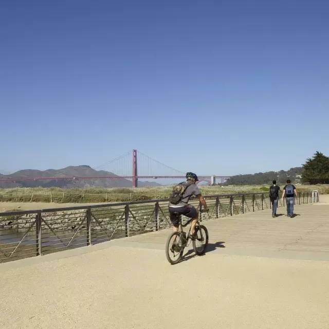 Ein Mann fährt mit dem Fahrrad einen Wanderweg am Crissy Field entlang. 贝博体彩app，加利福尼亚.